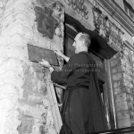 Le frère Georgius retire la plaque des frères du Sacré-Coeur de la façade de l'école Saint-Charles de Limoilou, le 23 juin 1959